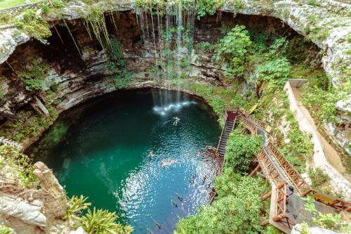 an aerial view of a pool of water with a waterfall at Oriundo Luxury Nature Villas in Valladolid