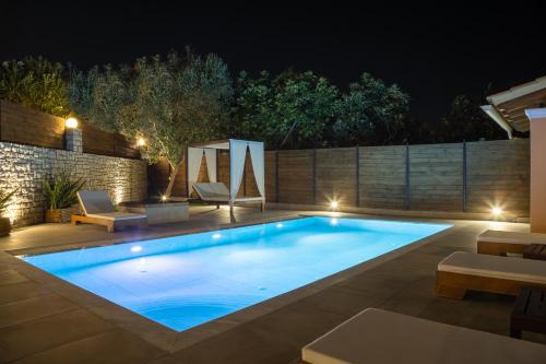 a swimming pool in a backyard at night at Villa Bella Donna Corfu in Corfu