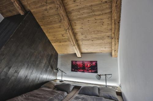 a bedroom with a bed and a wooden ceiling at Just Jimramov in Jimramov