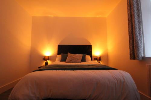 a bedroom with a large bed with two lamps at F4 Hammonds Row in Preston