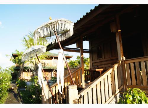 two white umbrellas on a porch of a house at Ti Amo Bali in Jatiluwih