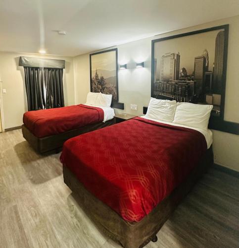 a hotel room with two beds with red sheets at Econo Lodge Union City - Atlanta South in Union City