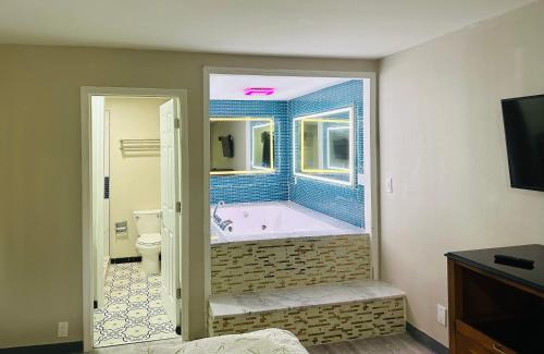 een badkamer met een bad, een toilet en een raam bij Econo Lodge Union City - Atlanta South in Union City