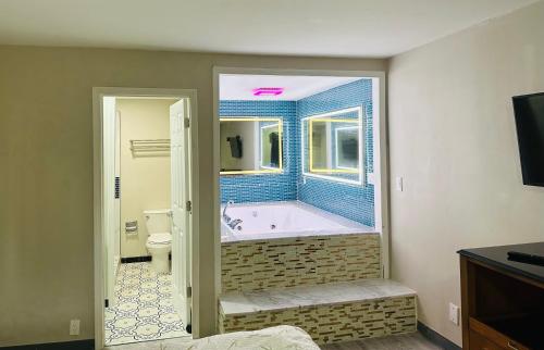 a bathroom with a tub and a toilet and a window at Econo Lodge Union City - Atlanta South in Union City