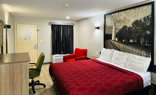 a hotel room with a red bed and a red chair at Econo Lodge Union City - Atlanta South in Union City