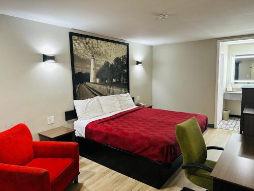 ein Hotelzimmer mit einem roten Bett und einem roten Stuhl in der Unterkunft Econo Lodge Union City - Atlanta South in Union City