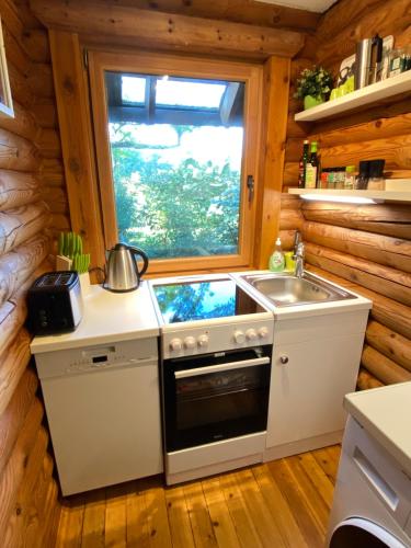 a kitchen with a stove and a sink and a window at Eifel-Lounge BLOCKHAUS in Weilerswist