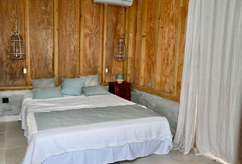 a bedroom with a bed with wooden walls at Les Hauteurs de Citronnelles in Case-Pilote