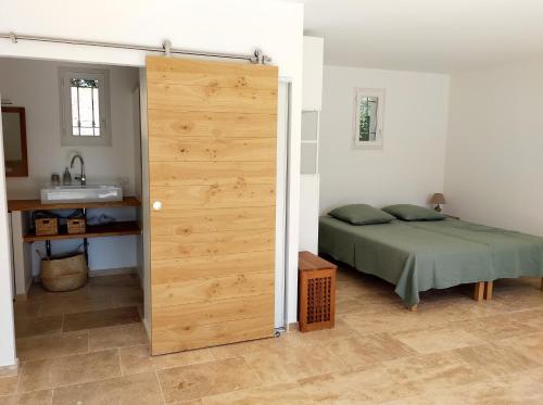 ein Schlafzimmer mit einem Bett und einer Schiebetür in der Unterkunft Grand Studio L'Imprévu de Correns in Correns