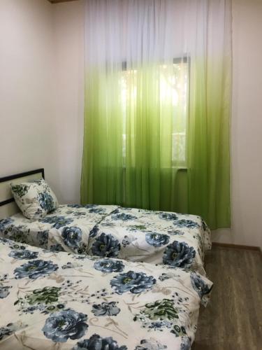 sypialnia z 2 łóżkami i zieloną zasłoną w obiekcie Hasy tun Guest House in GARNI 2 w Garni