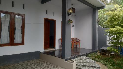 eine Veranda eines Hauses mit einer Holztür in der Unterkunft Soraya Homestay in Tulungagung