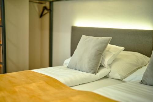 una cama con almohadas blancas encima en Ice Premium Apartments en Veszprém