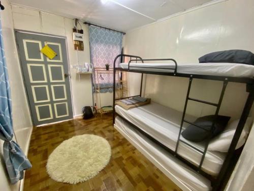 a dorm room with bunk beds and a rug at Global Star Chalet in Kampong Batang Tiga
