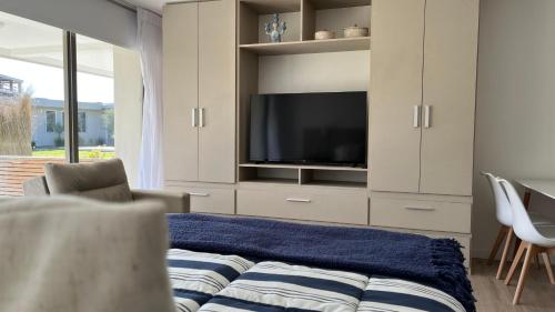 a living room with a tv and a couch at SYRAH Premium B1 - Vistas al Parque by depptö in Punta del Este