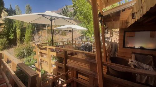 an outdoor patio with a television and an umbrella at Hostal Crisol in Lo Valdés
