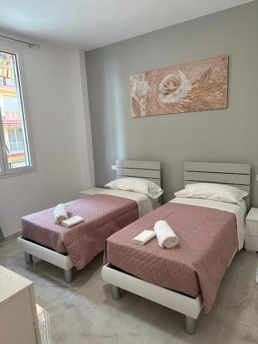 a bedroom with two beds with towels on them at CASA ANGELA Vista mare in Ventimiglia