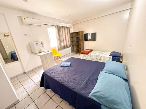 een slaapkamer met een blauw bed en een gele stoel bij Hotelcity in Brusque