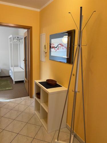 a yellow room with a counter and a tv on the wall at Appartement Am Weinberg in Radebeul