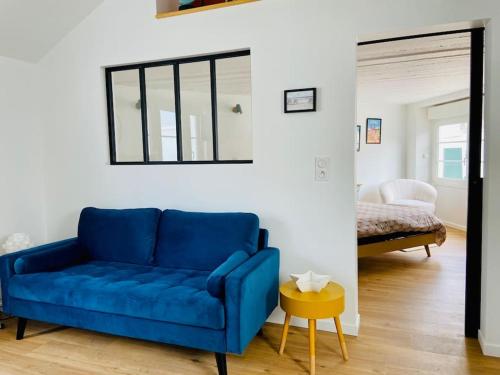 um sofá azul numa sala de estar com um quarto em La p'tite Nouba à 300m de la mer em Cayeux-sur-Mer