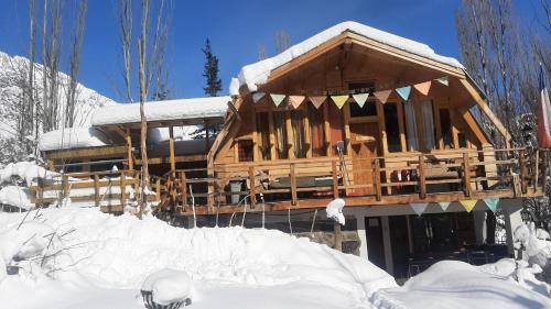 a large wooden house in the snow with snow at Hostal Crisol in Lo Valdés