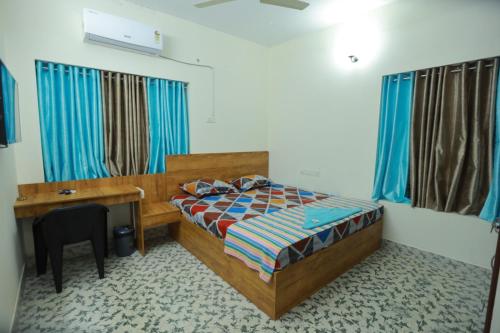 a bedroom with a bed and a desk and a desk at Ritu Homestay in Trivandrum