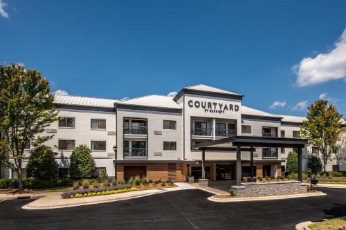 a large white building with a parking lot at Courtyard by Marriott Charlotte Ballantyne in Charlotte
