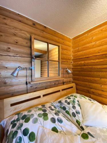 a bedroom with wooden walls and a bed with a mirror at Eifel-Lounge BLOCKHAUS mit Kamin Garten Balkon nahe Köln Therme Brühl Phantasialand in Weilerswist