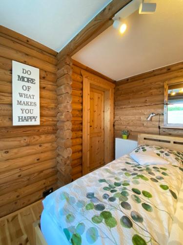 a bedroom with a bed and a sign on the wall at Eifel-Lounge BLOCKHAUS mit Kamin Garten Balkon nahe Köln Therme Brühl Phantasialand in Weilerswist