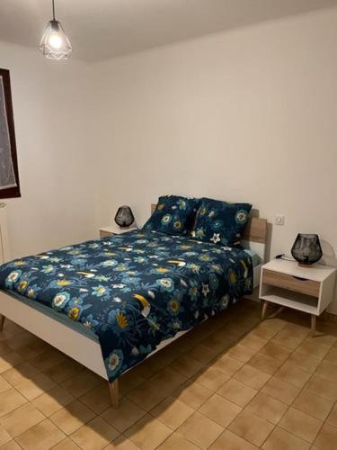 sypialnia z łóżkiem z niebieską kołdrą w obiekcie Jolie maison à louer dans les Cévennes w mieście Saint-Christol-lès-Alès