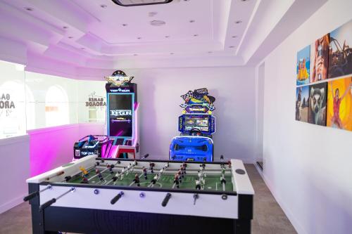 a room with a foosball table and arcade games at Ramada Hotel & Suites by Wyndham Costa del Sol in Fuengirola