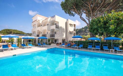 una piscina di fronte a un hotel con sedie e ombrelloni di Family Spa Hotel Le Canne a Ischia