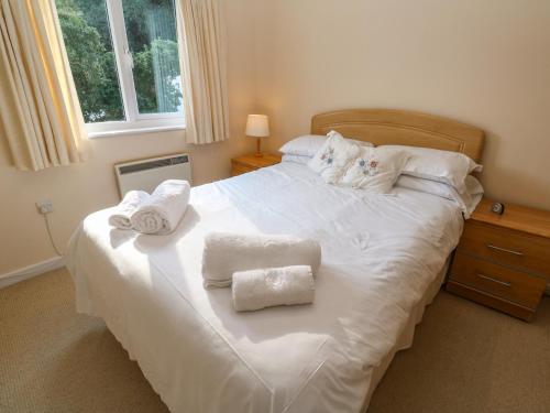 a bedroom with a white bed with towels on it at Primrose Cottage in Falmouth