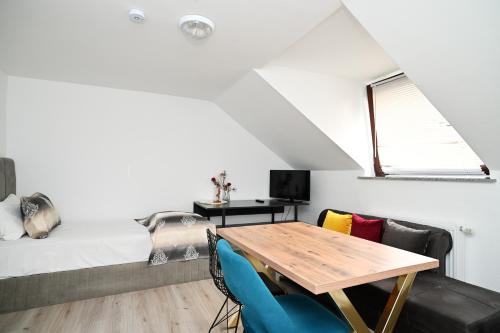 Habitación con mesa, sillas y cama en Ferienwohnung&Aparts By kispet group hotels in Oberhausen en Oberhausen