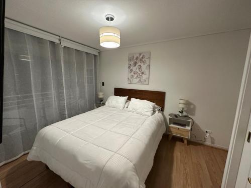 Un dormitorio con una gran cama blanca y una ventana en Depto LAS CONDES-EST ESPAÑOL en Santiago