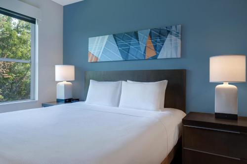 a bedroom with a large white bed with two lamps at Hyatt House Mall Of America Msp Airport in Bloomington