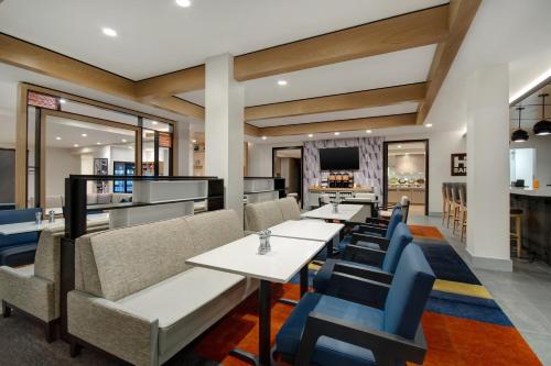 a dining room with tables and blue chairs at Hyatt House Mall Of America Msp Airport in Bloomington