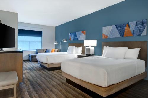 a hotel room with two beds and a flat screen tv at Hyatt House Mall Of America Msp Airport in Bloomington