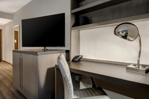 a room with a desk with a television and a lamp at Hyatt House Mall Of America Msp Airport in Bloomington