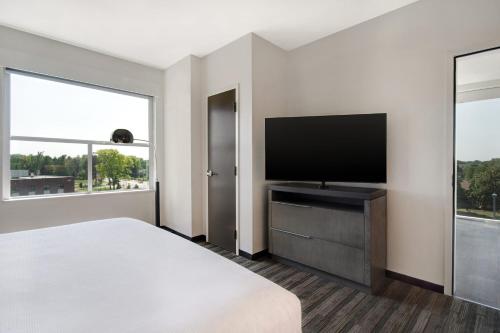 a hotel room with a bed and a flat screen tv at Hyatt House Mall Of America Msp Airport in Bloomington