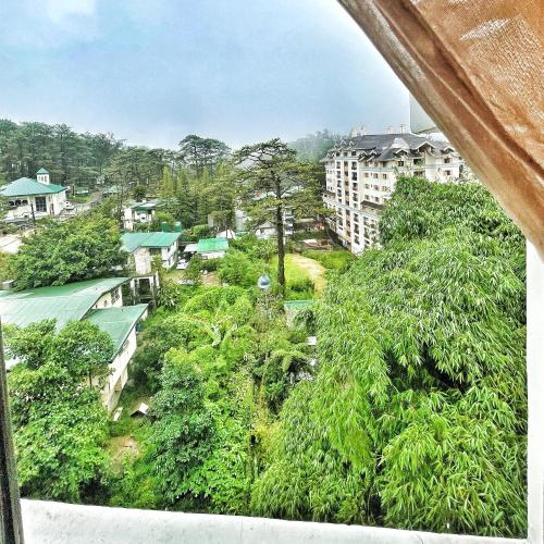 uma vista para uma cidade com árvores e edifícios em QFandZ Baguio Homestay at BRENTHILL Condominium em Baguio