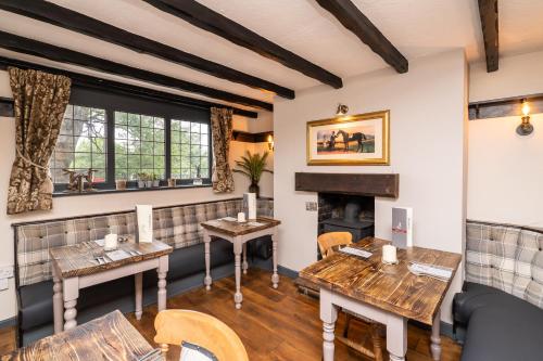 a restaurant with wooden tables and a fireplace at The Strawbury Duck Inn in Darwen