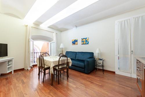 uma sala de estar com uma mesa e um sofá azul em Maison Indipendenza em Bolonha