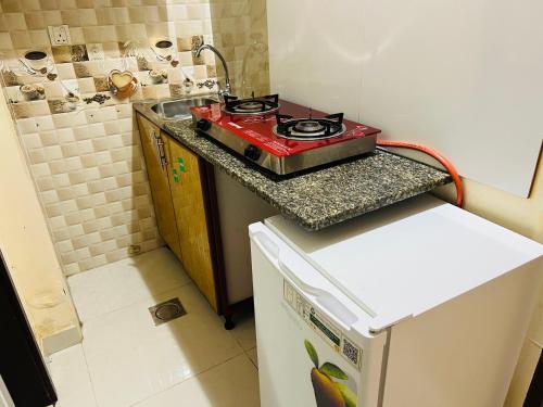 a small kitchen with a stove on top of a refrigerator at Cozy Studio Apartment 2 in Dubai