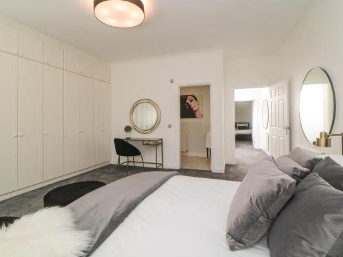um quarto branco com uma cama grande e um espelho em Brompton Gardens em Torquay