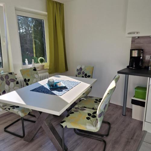 a dining room with a white table and chairs at Ferienwohnung Vier Pfoten in Willingen