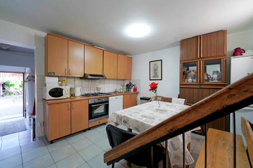 a kitchen with a table and a white refrigerator at Skruzdėlynas in Nida