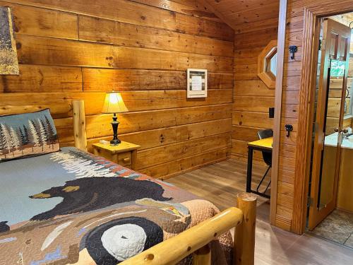 1 dormitorio con 1 cama en una cabaña de madera en My Happy Place, en Pigeon Forge