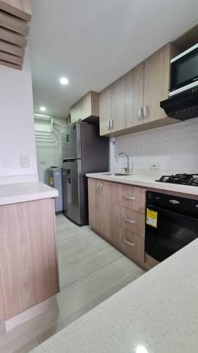 a kitchen with wooden cabinets and a stove top oven at Apartamento en Guabinas Yumbo in Puerto Isaacs