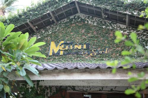un cartel en la parte superior de un edificio con plantas en Mui Ne Resort, en Mui Ne