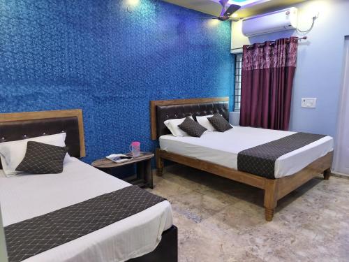 - une chambre avec 2 lits et un mur bleu dans l'établissement DayLight Stay, à Chennai